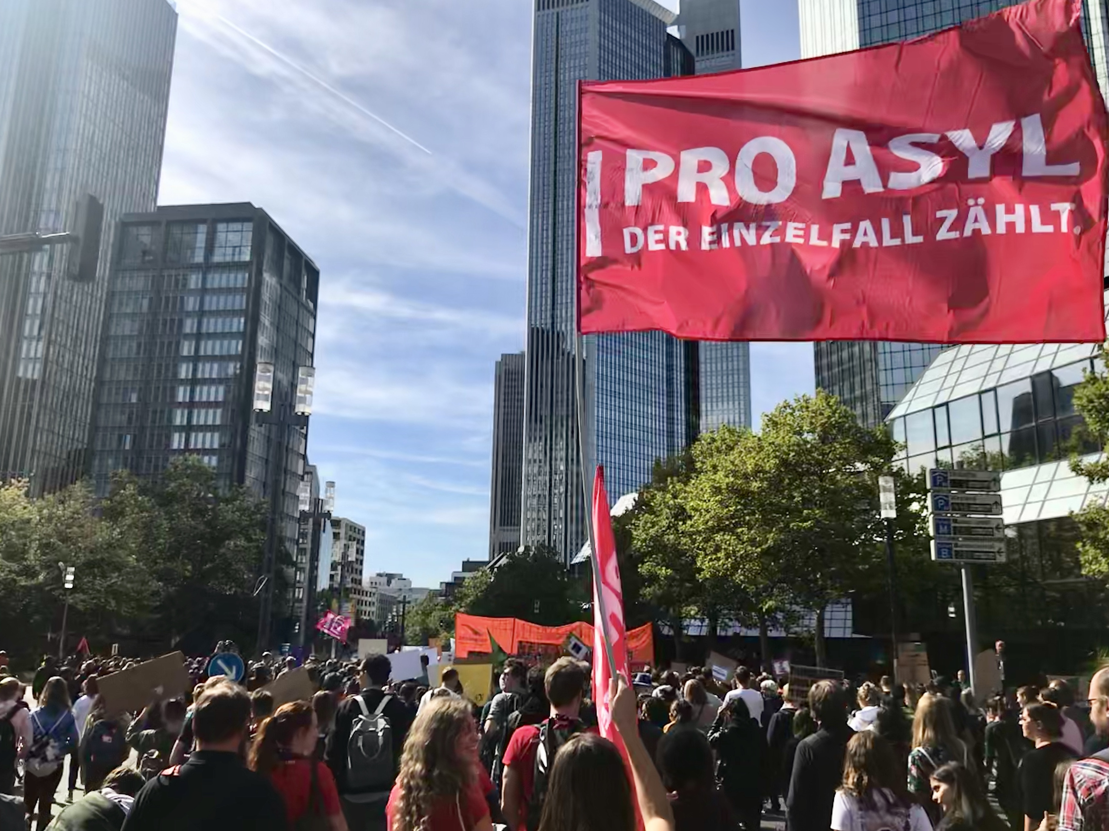 Auf einer Demo wird die Flagge von Pro Asyl hochgehalten.